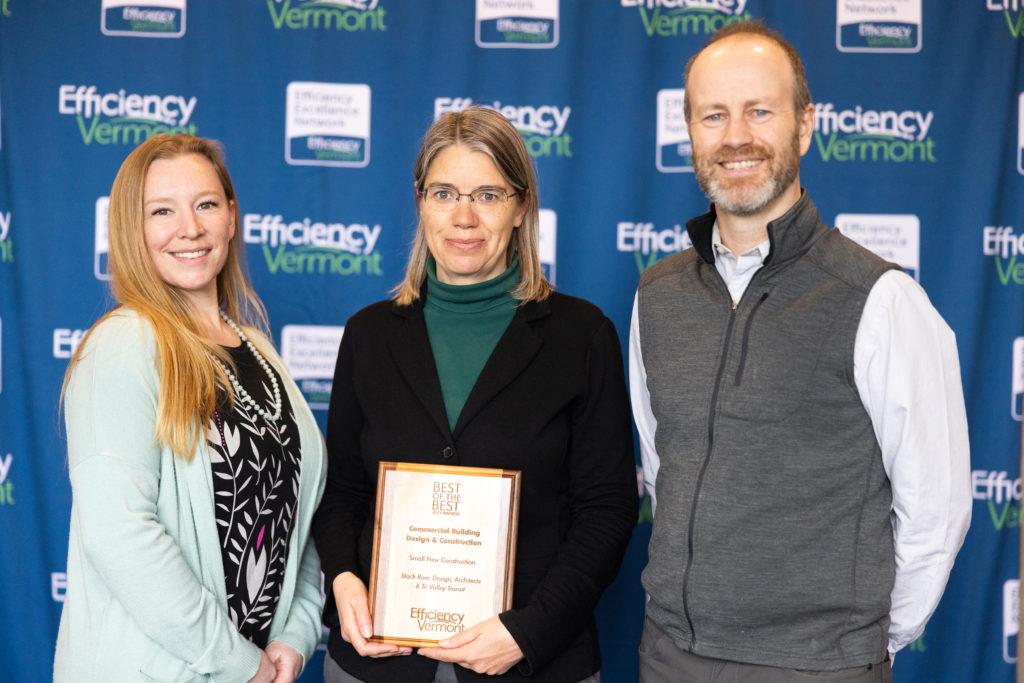Photo of Jade McClallen of TVT and Polly Wheeler from Black River Design receiving an award from Mike Crowley of Efficiency Vermont